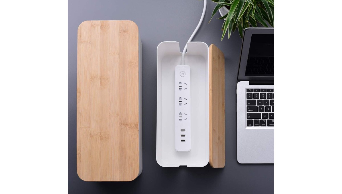 A closed Chouky Large-Cable-Management Box and an open one sit on a desk with a laptop and a plant. A closed Chouky Large-Cable-Management Box and an open one sit on a desk with a laptop and a plant.