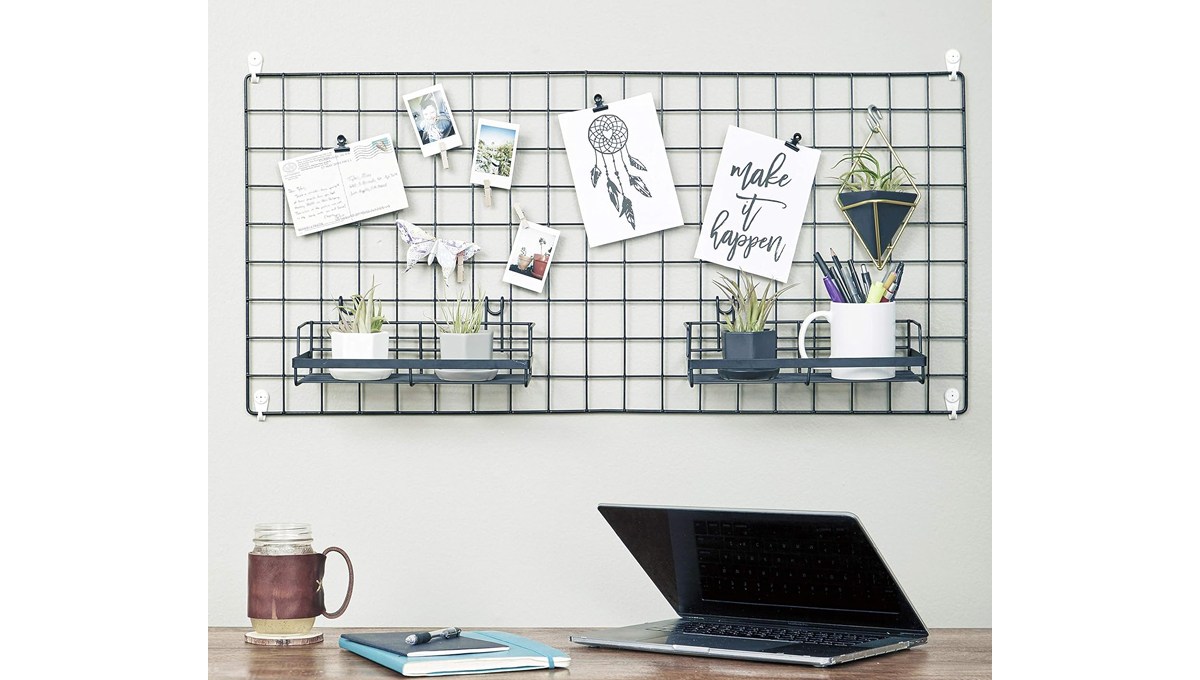 The TRUSTODY Wire Hanging Wall Grid hanging on a wall behind a desk with a drinking glass, book and laptop on it. The TRUSTODY Wire Hanging Wall Grid hanging on a wall behind a desk with a drinking glass, book and laptop on it.