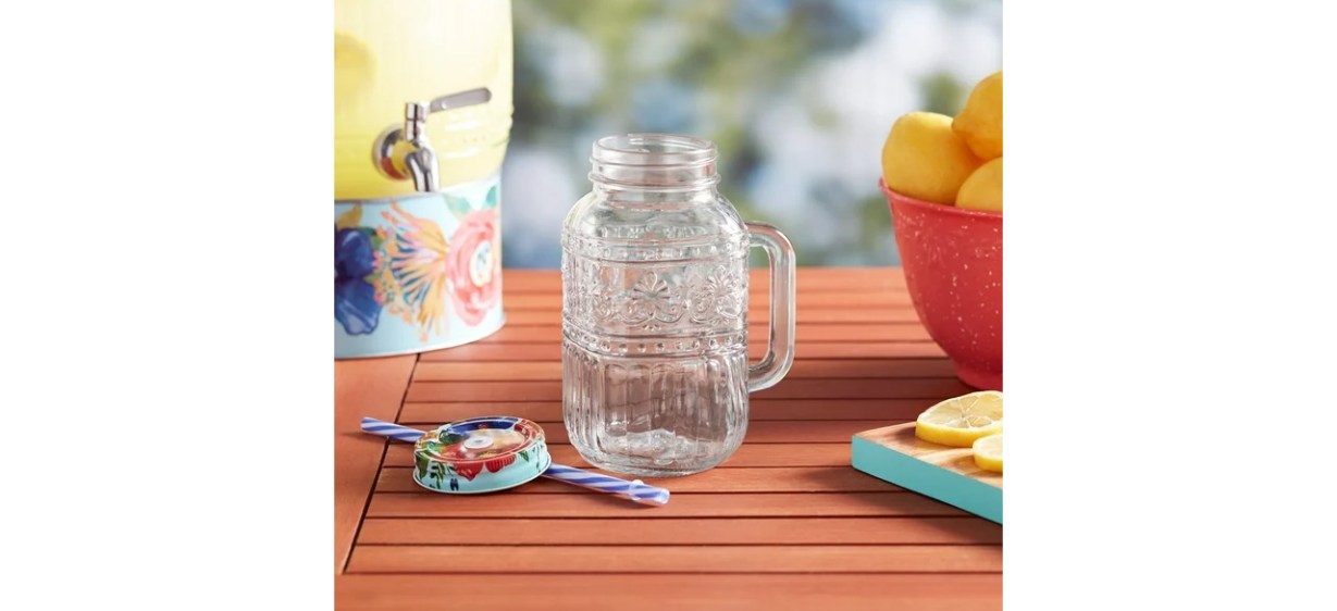 The Pioneer Woman Cassie 32-Fluid-Ounce Mason Jar Tumbler, Clear on table The Pioneer Woman Cassie 32-Fluid-Ounce Mason Jar Tumbler, Clear on table